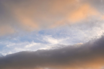 Orange, wavy clouds in the blue sky.