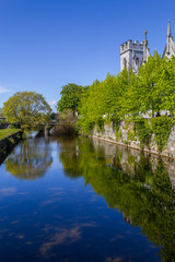 Fototapeta na wymiar Corrib river with church, vegetation and reflection