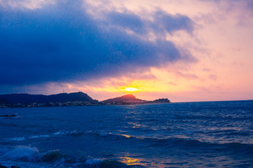 Naklejka na ściany i meble Sunset Sea Perspective from the Shoreline, Beautiful Mountain and Ocean view Landscape, Shimmering Twilight with blue and dark colors, Hidding Sun between Cloudy Sky