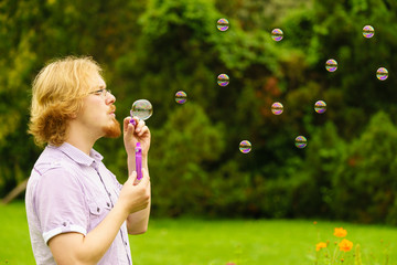 Man blowing soap bubbles outdoor