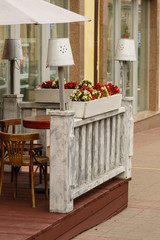 part of a street summer cafe with a table and chairs and lamps