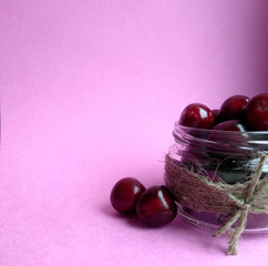 red sweet cherry. sweet cherry in bank on a pink background. free space.