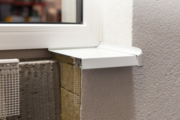 Layered insulated wall with plaster, glue, net, polystyrene, thermal protection and plastic window sill