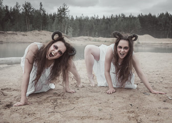 Two screaming demons with horns in white shirt