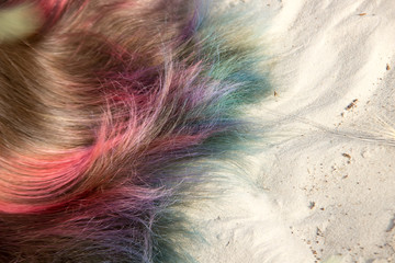 Painted in different colors hair on the sand.