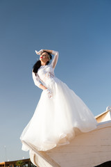 Fototapeta na wymiar Her perfect day. Things consider for wedding abroad. Bride adorable white wedding dress sunny day posing on boat or ship. Wedding ceremony sea cruise. Advice and tips from wedding abroad experts