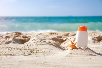 Protective sunscreen or sunblock and sunbath lotion in white plastic bottles on tropical beach, summer accessories in holiday.