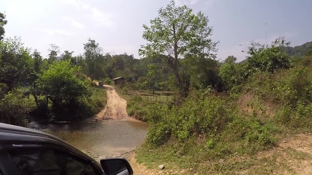 Crossing a river during an offroad tour through the north-western parts of Laos countryside