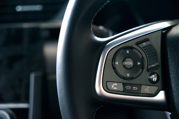 Audio control and speakerphone buttons on the steering wheel of a Car modern interior.