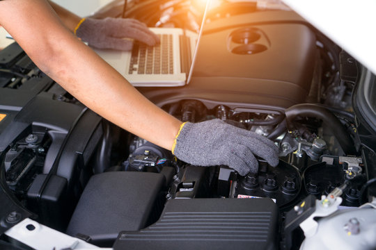 Car repair service, Auto mechanic checking battery in a engine.