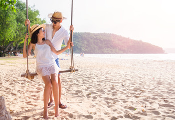Asian happy couple in summer on the beach in a tropical place. lovers in vacation in an idyllic nature scene sharing positive feelings and emotions.