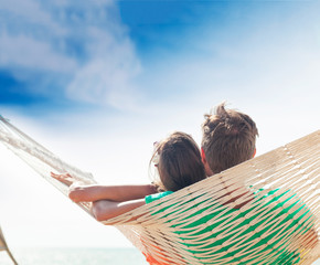 Young couple in love relaxing in a hammock by the beach