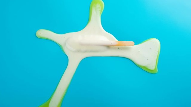 
studio shoot of yellow popsicle melting and reverse on blue time lapse
