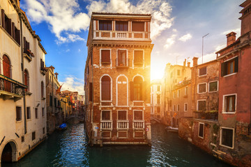 View of the street canal in Venice, Italy. Colorful facades of old Venice houses. Venice is a popular tourist destination of Europe. Venice, Italy.