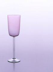 Champagne glass on a light purple  background, studio shot. Menu for graduation. Wine list with copy space. Pink champagne glass, minimalism. 