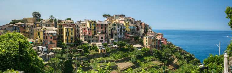 Fototapeta na wymiar Panoramic View of the city of Corniglia on Blue Sky and Sea Background in the Italian National Park of the Cinque Terre.