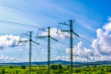 Three high voltage transmission towers over cloudy sky