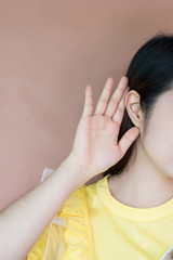 Fototapeta premium Close up woman holds her hand near ear and listens carefully,Listening woman holds his hand near his ear,gossip,
