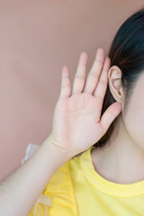 Close up woman holds her hand near ear and listens carefully,Listening woman holds his hand near his ear,gossip,