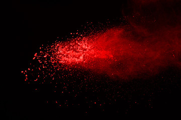 Abstract red dust explosion on black background. abstract red powder splatted on black background....