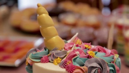 Moving shot of colourful birthday cake unicorn themed
