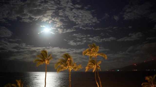 Clouds, moon and stars moving over ocean