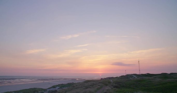 Gold hour sunset in Denmark Scandinavia Europe on beach with people walking