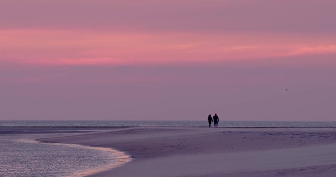 Gold hour sunset in Denmark Scandinavia Europe on beach with people walking