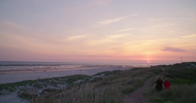 Gold hour sunset in Denmark Scandinavia Europe on beach with people walking