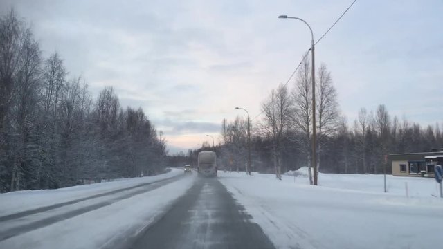 Snow covered road filmed through windscreen