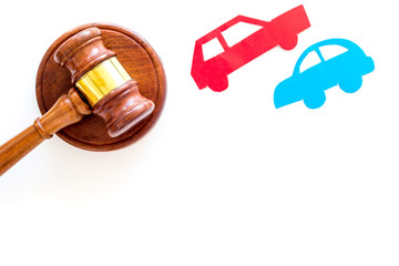 Car accident lawsuit concept. Two collided cars near judge gavel on white background top view copy...