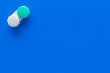 Contact lenses in container on blue background top view copy space