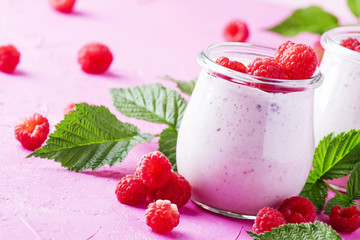 Raspberry smoothie with berry and yogurt on pink background, selective focus