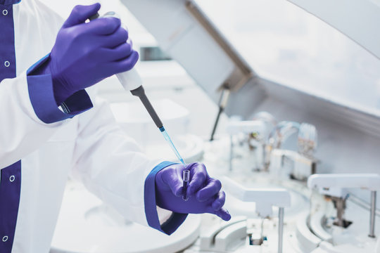 Scientific laboratory. Competent practitioner holding medical instrument while doing paternity analysis