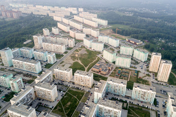 Fototapeta na wymiar Aerial city view with crossroads, roads, houses, buildings, parks, parking lots, bridges