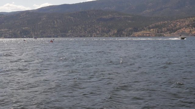 Slow Motion Two Men Kayaking in Lake Beside Motor Boat in the Summer