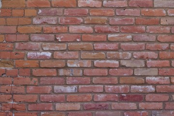 Attractive old weathered traditional clay brick wall in colors of brown, pink, gray, and white