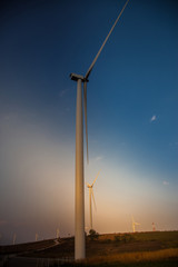 Fototapeta na wymiar Wind turbine farm of silhouette at sunset.