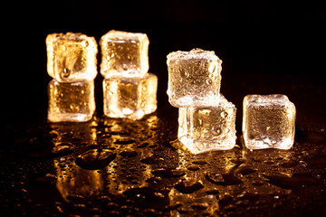 Golden ice cubes on black background.