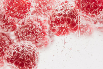 Fresh raspberries in water wiht air bubbles.