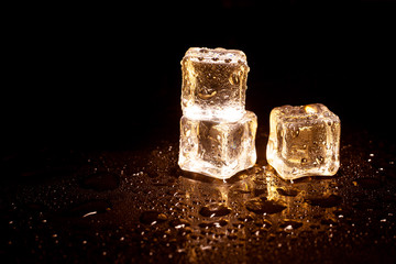 Golden ice cubes on black background.