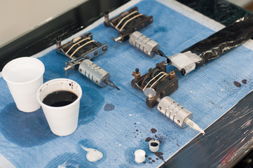 Tattoo machines on blue work station