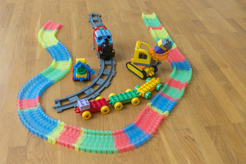 Children's toys on the floor. Close-up. Children's excavator, train and car
