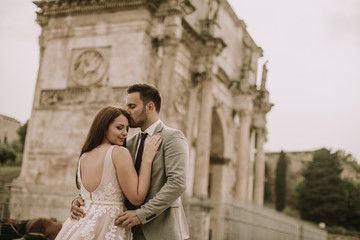 Young wedding couple by Arch of Constantine in Rome
