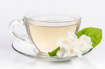Obraz na płótnie Canvas Glass cup of Tea with jasmine flowers