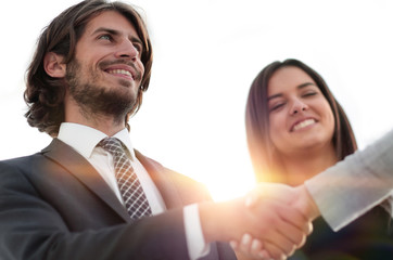 Businesspeople  shaking hands against room with large window loo