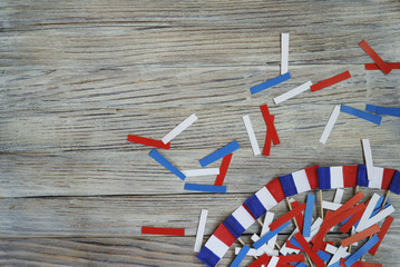 Paper confetti of the national colors of France, white-blue-red on a white wooden background with...