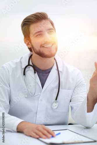 Smiling Doctor Sitting Behind A Desk Stock Photo And Royalty Free