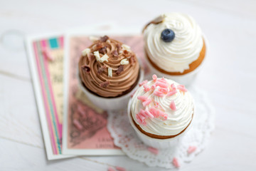 Sweet food composition with creamy cupcakes decorated with chocolate and berries