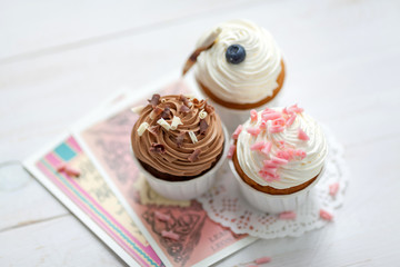 Sweet food composition with creamy cupcakes decorated with chocolate and berries